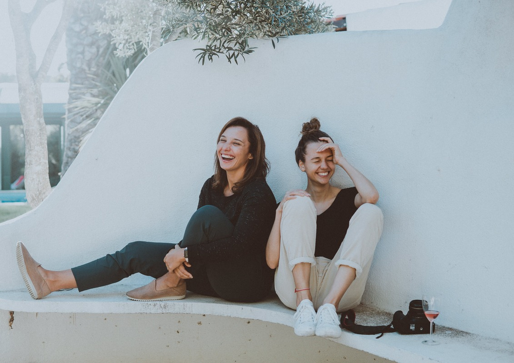 Photo de deux jeunes femmes assises en train de rire