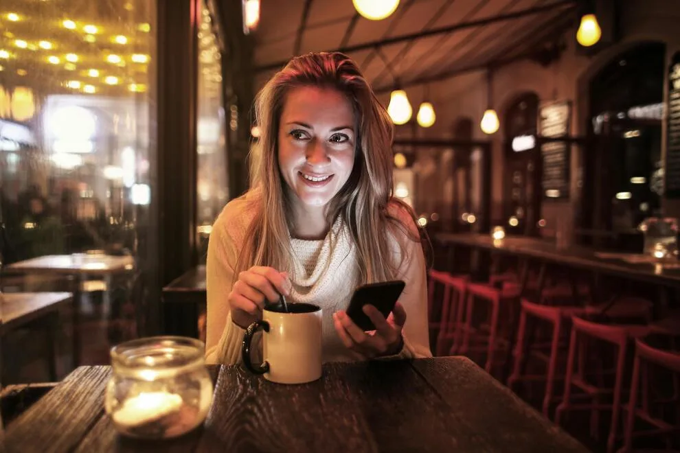 Jeune femme souriante assise à un café