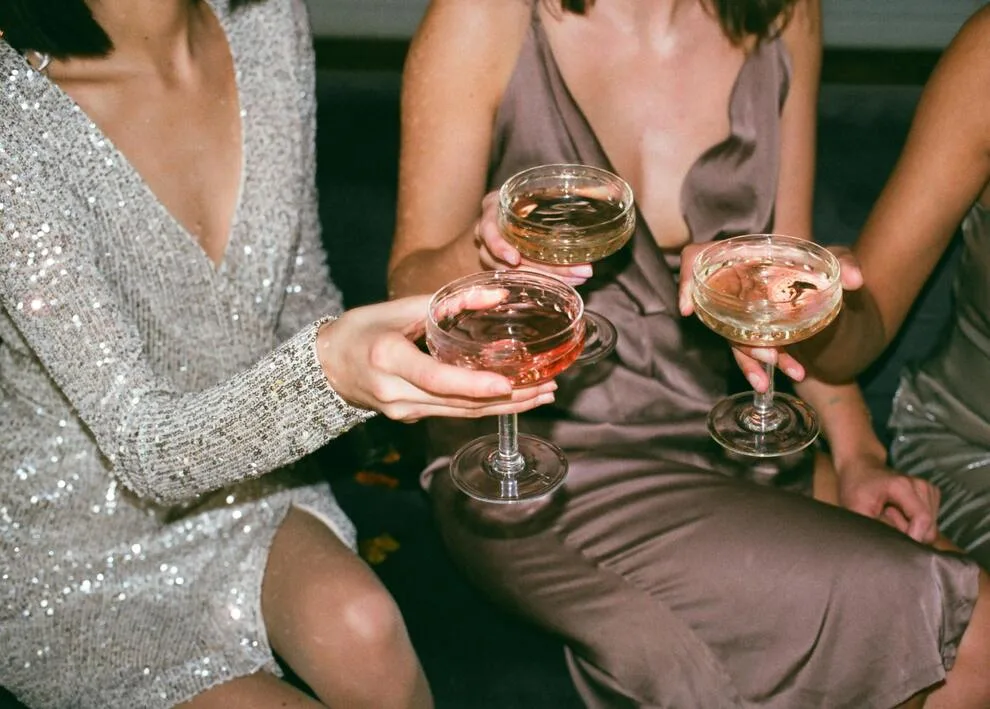 Trois amies en tenue de soirée en train de trinquer