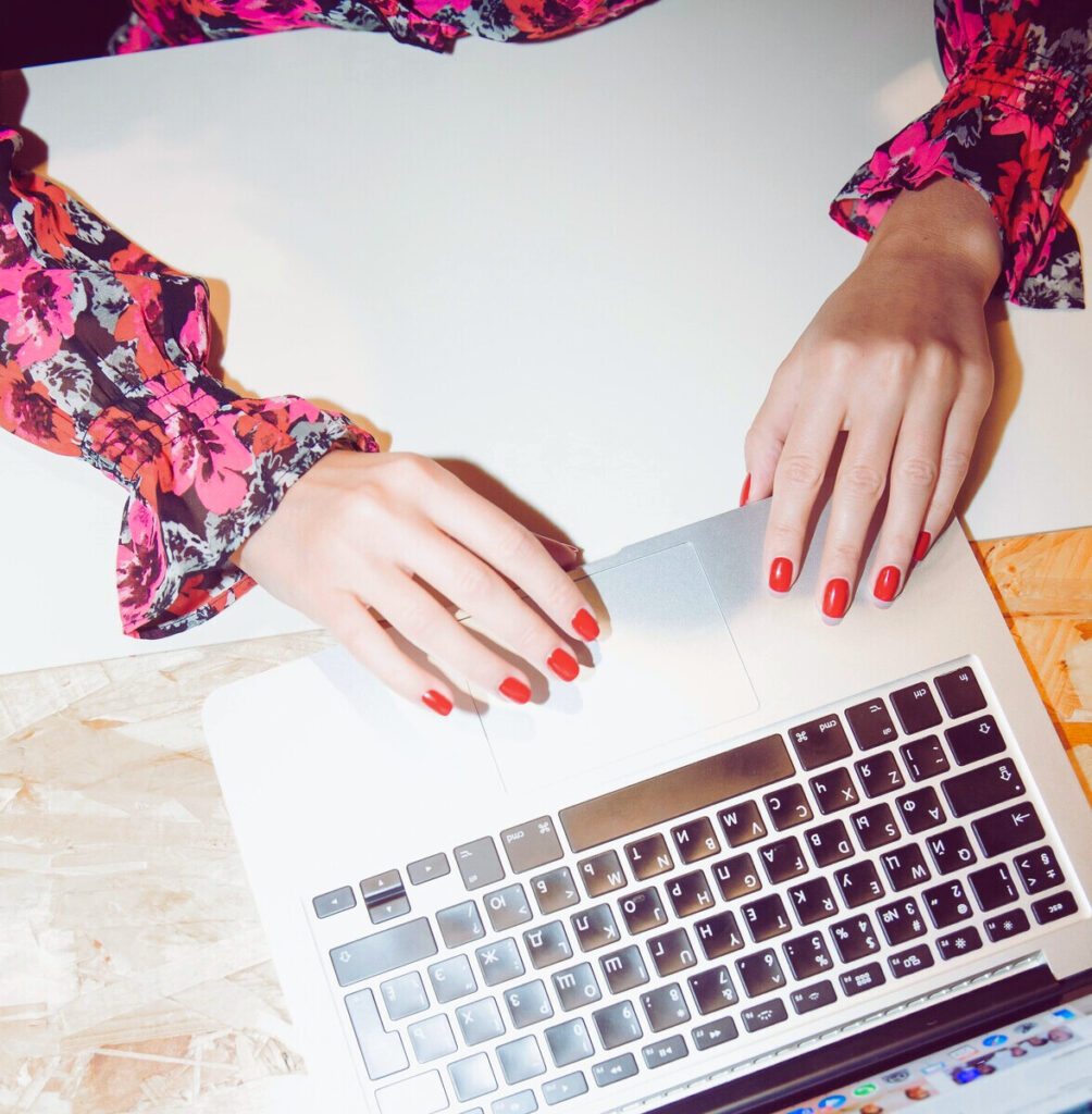 Rédactrice web avec ongles rouges pianote sur clavier d'ordinateur