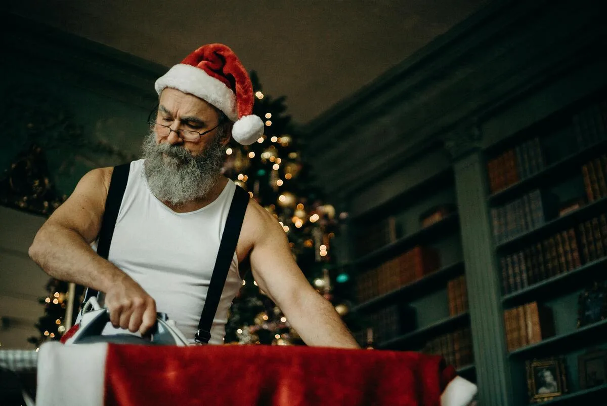Père Noël en train de repasser son costume - Les plus belles pubs de Noël 2024