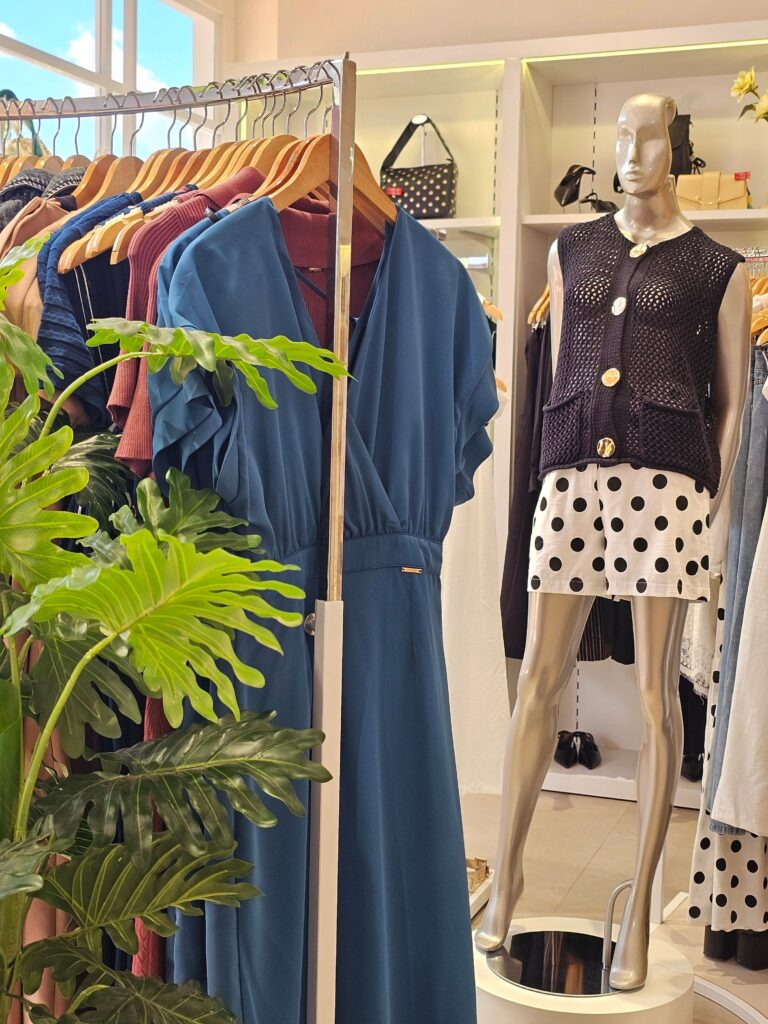 Elegant fashion display in a boutique showcasing stylish dresses and a mannequin.